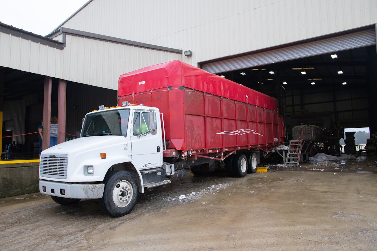 Crafting Captivating Headlines: Your awesome post title goes here Red trailer truck at a warehouse loading dock, ready for delivery.